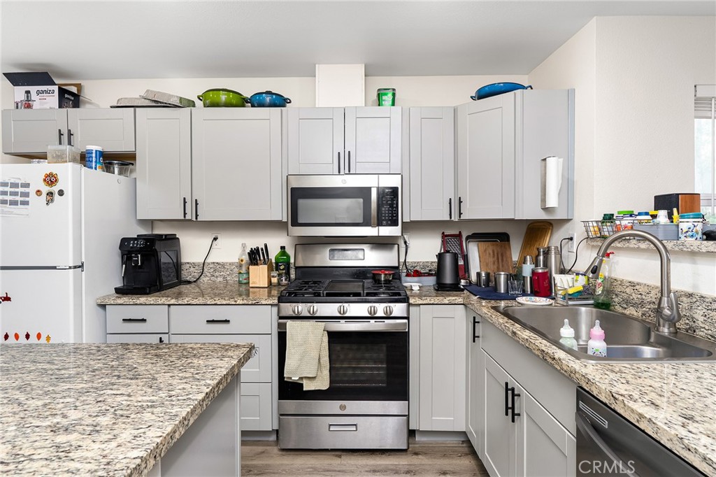 6033 Pentz Road Paradise, CA 95969 - Photo 19 of 54 a kitchen with kitchen island granite countertop a sink a stove and refrigerator