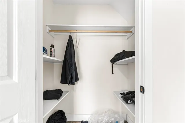 a view of a hallway with wooden floor and closet