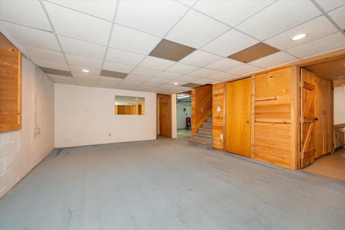 404 Alcohol Road Wrenshall, MN 55797 - Photo 18 of 32 Finished basement with wood walls, stairs, recessed lighting, a paneled ceiling, and carpet