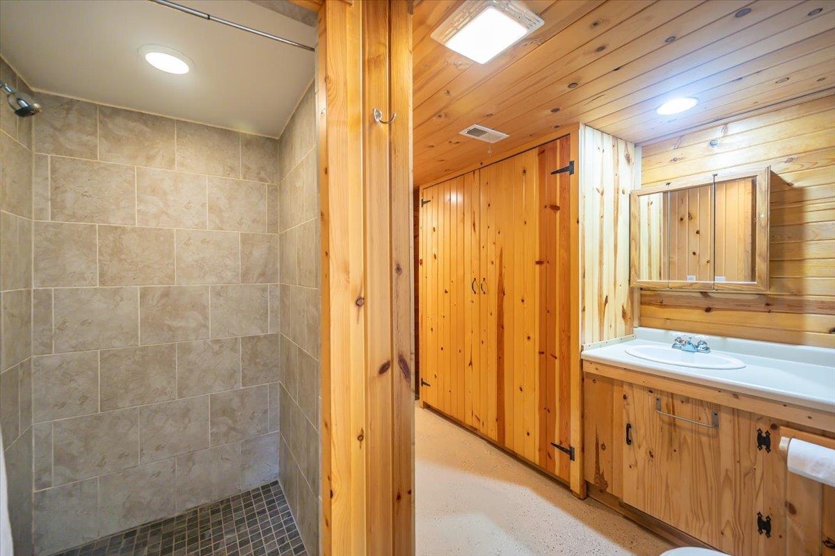 404 Alcohol Road Wrenshall, MN 55797 - Photo 21 of 32 Full bath with a stall shower, vanity, recessed lighting, and wooden walls