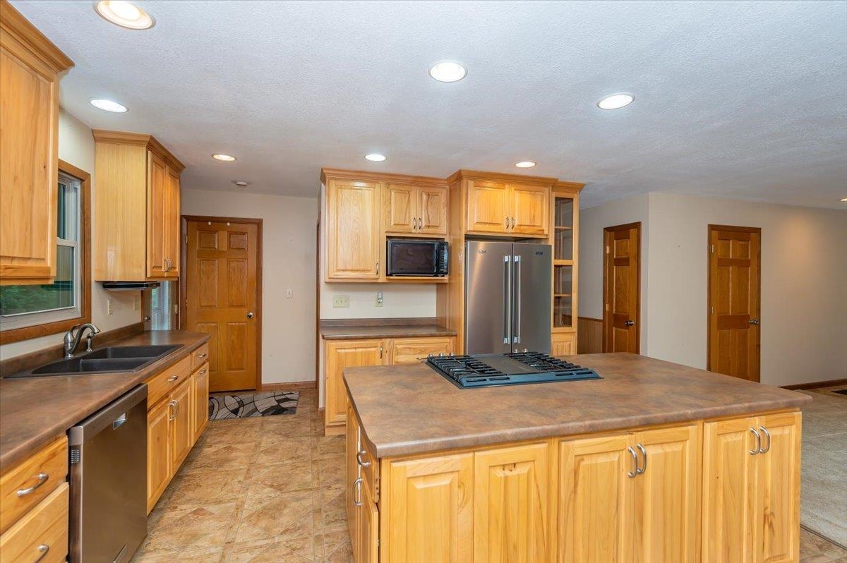 404 Alcohol Road Wrenshall, MN 55797 - Photo 4 of 32 Kitchen featuring recessed lighting, stainless steel appliances, a center island, glass insert cabinets, and dark countertops