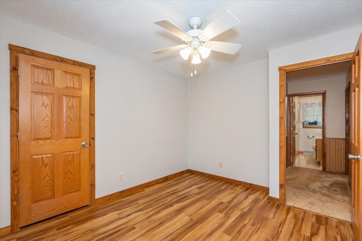 404 Alcohol Road Wrenshall, MN 55797 - Photo 9 of 32 Unfurnished bedroom featuring light wood-style floors, a textured ceiling, and ceiling fan