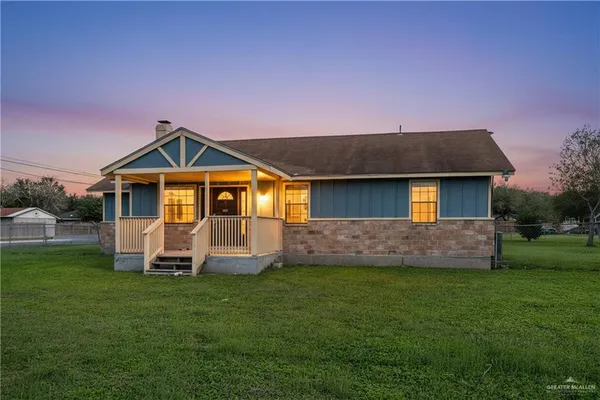 a front view of a house with a garden and yard
