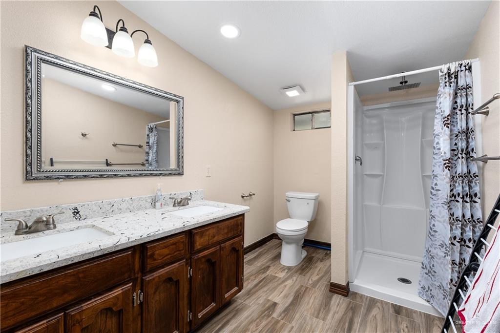 310 North Arroyo Boulevard Rio Hondo, TX 78583 - Photo 13 of 31 a bathroom with a double vanity sink mirror and toilet