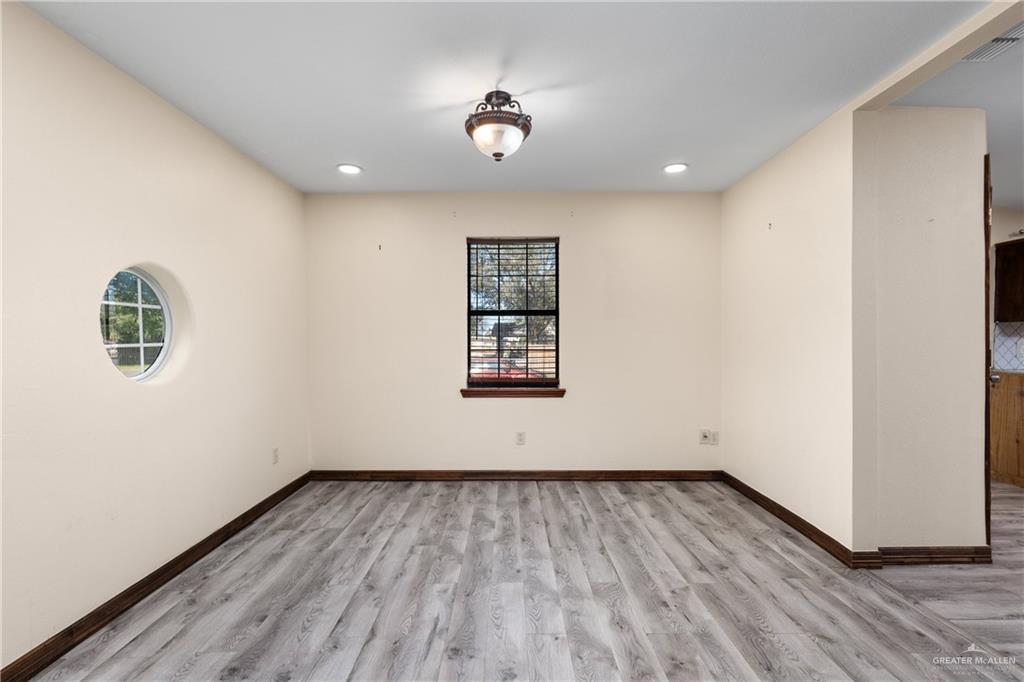 310 North Arroyo Boulevard Rio Hondo, TX 78583 - Photo 7 of 31 a view of an empty room with wooden floor and a window