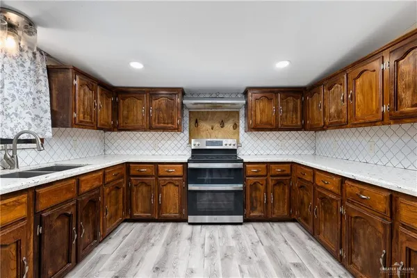 a kitchen with stainless steel appliances granite countertop wooden cabinets a stove top oven a sink and dishwasher