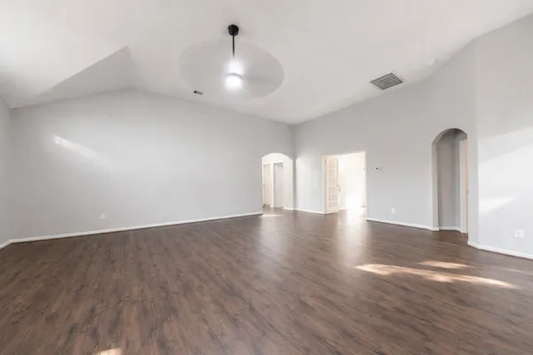 a view of an empty room with wooden floor