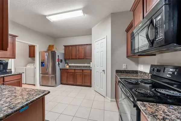 a kitchen with stainless steel appliances granite countertop a refrigerator and a sink
