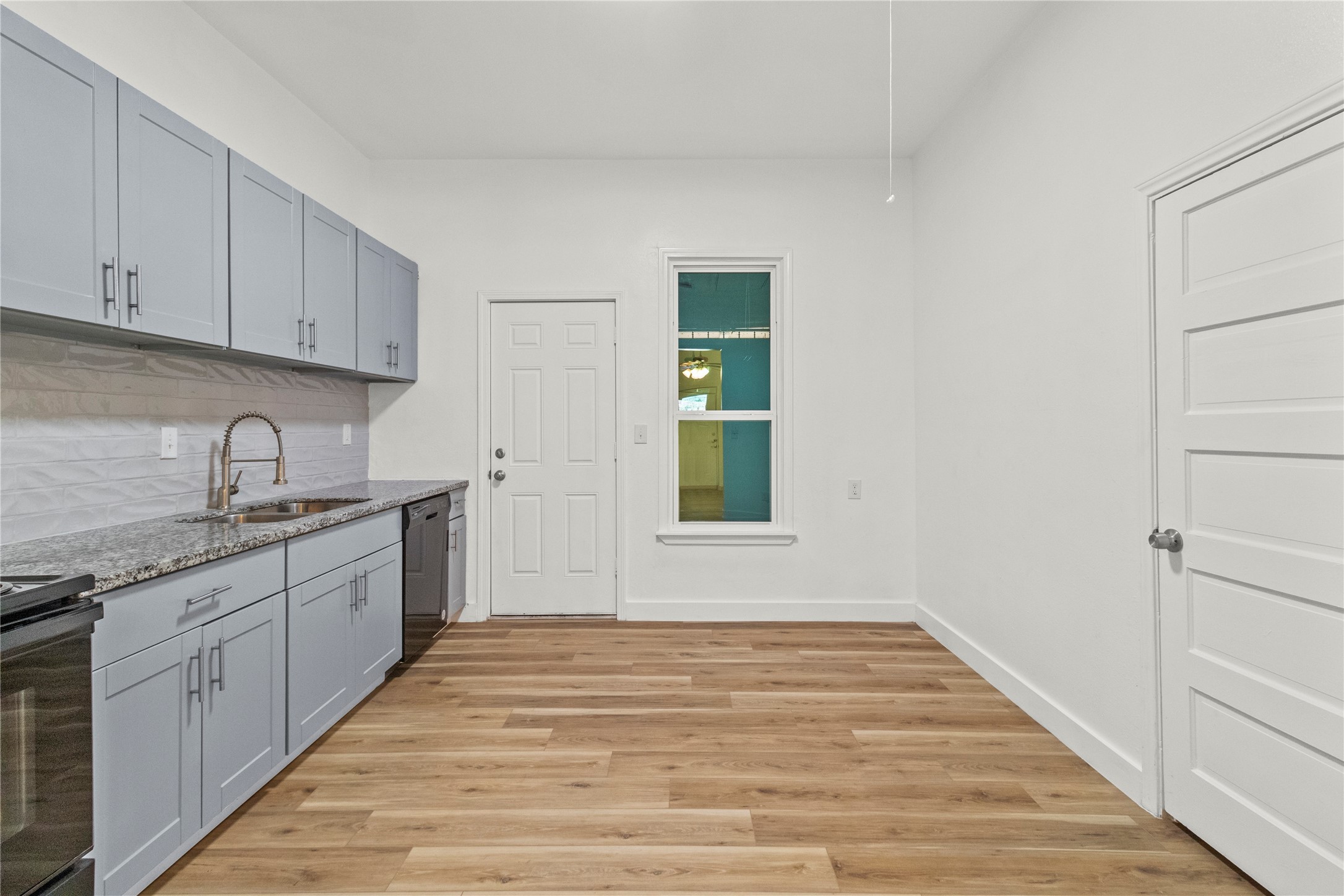 436 East Peach Street, Unit B Angleton, TX 77515 - Photo 6 of 7 a large white kitchen with granite countertop a sink