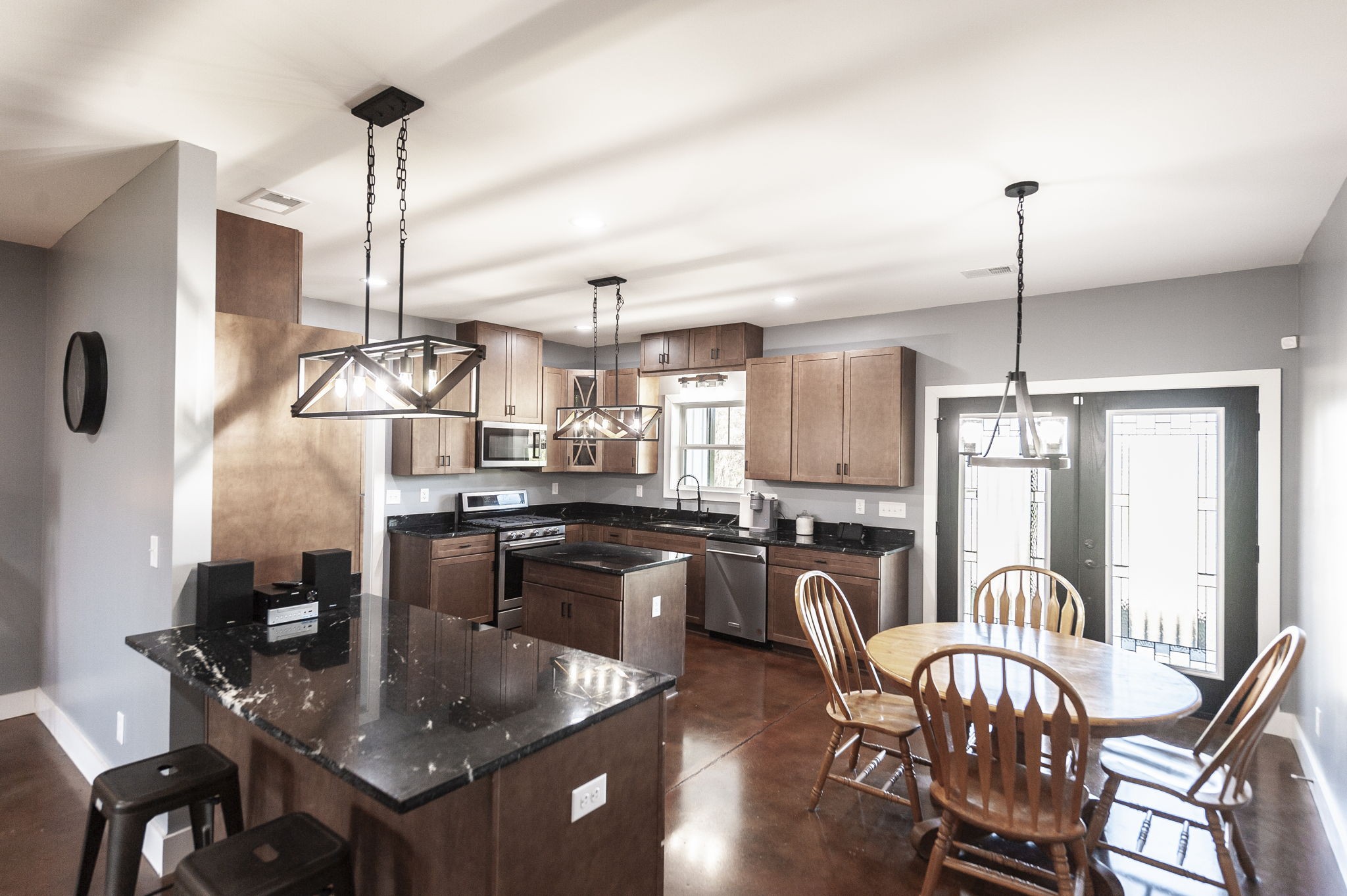 223 Cedar Hill Road Adams, TN 37010 - Photo 20 of 51 a kitchen with stainless steel appliances granite countertop a stove top oven a dining table and chairs with wooden floor