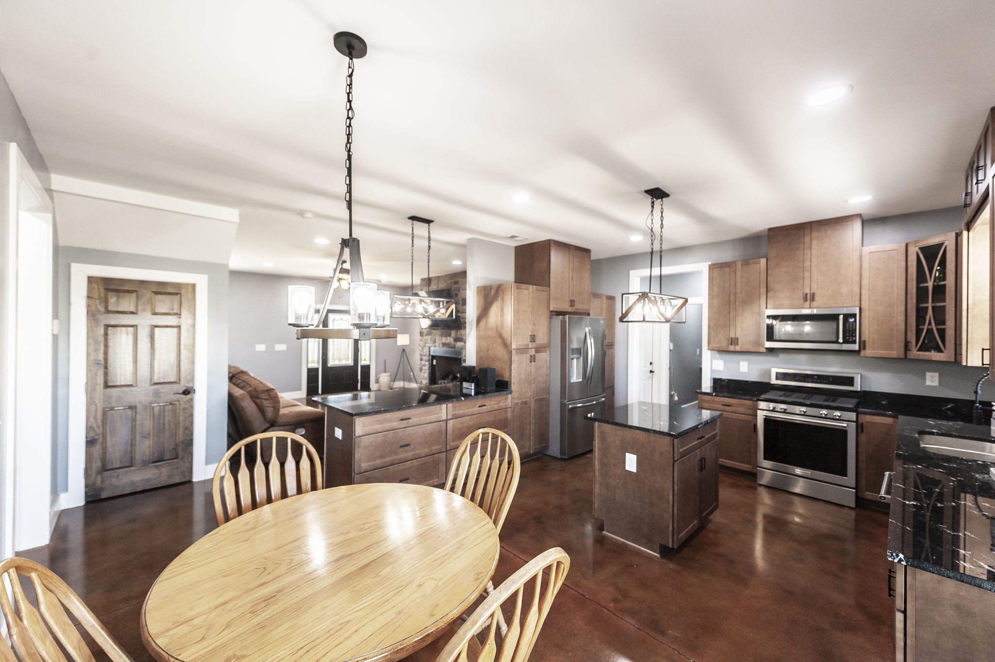 223 Cedar Hill Road Adams, TN 37010 - Photo 23 of 51 a kitchen island with stainless steel appliances granite countertop a stove a refrigerator a kitchen island a dining table and chairs with wooden floor