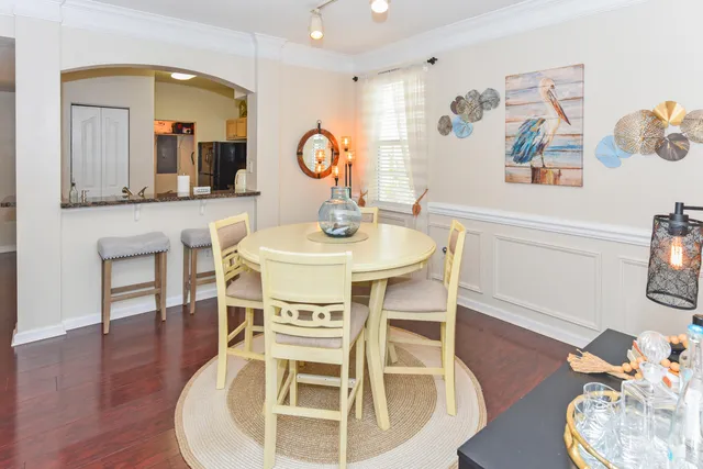 a dining room with wooden floor a glass table and chairs