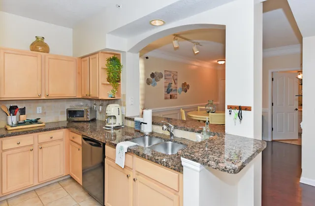 a kitchen with white cabinets and sink