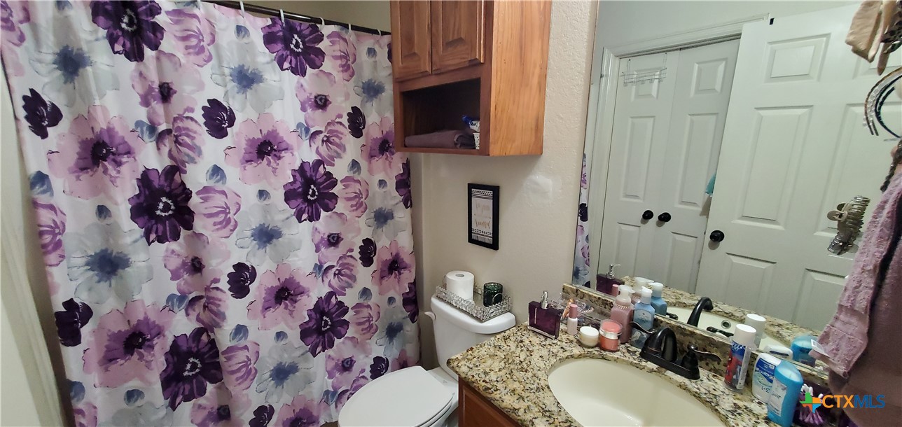 2201 Valley Forge Avenue Temple, TX 76504 - Photo 12 of 15 a bathroom with a granite countertop toilet sink and a mirror