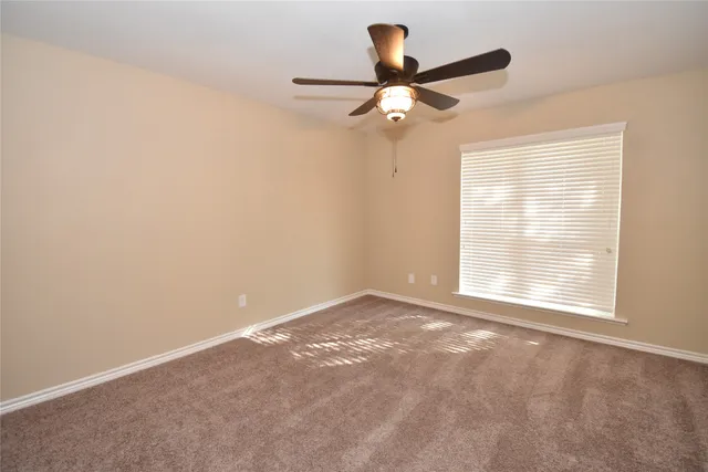 a view of a livingroom with a ceiling fan and window