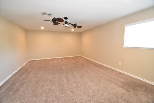 an empty room with a chandelier fan