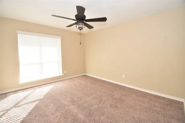 a view of a livingroom with a ceiling fan and window