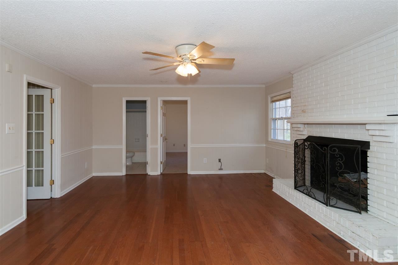 5827 Russell Road Durham, NC 27712 - Photo 11 of 25 a view of empty room with wooden floor and fireplace