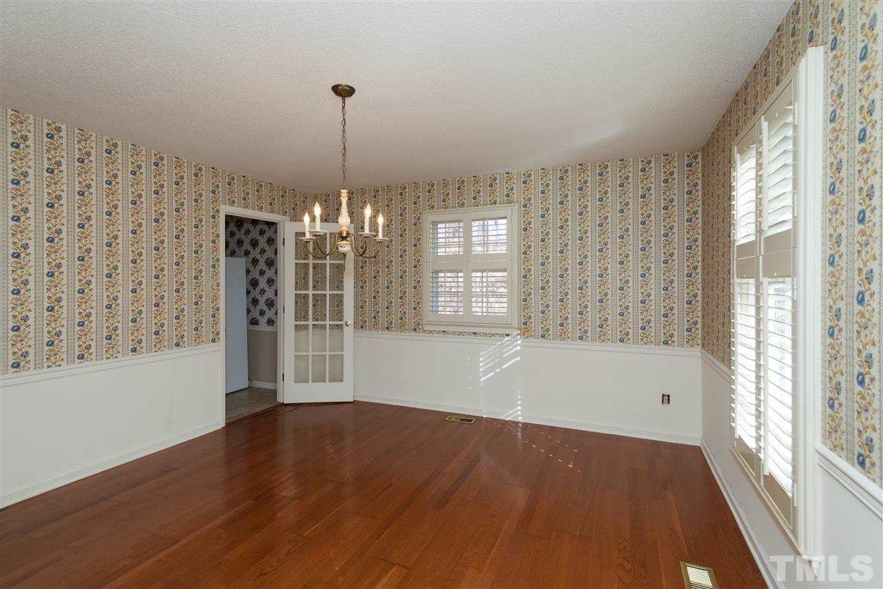5827 Russell Road Durham, NC 27712 - Photo 5 of 25 a view of an empty room with wooden floor and a window