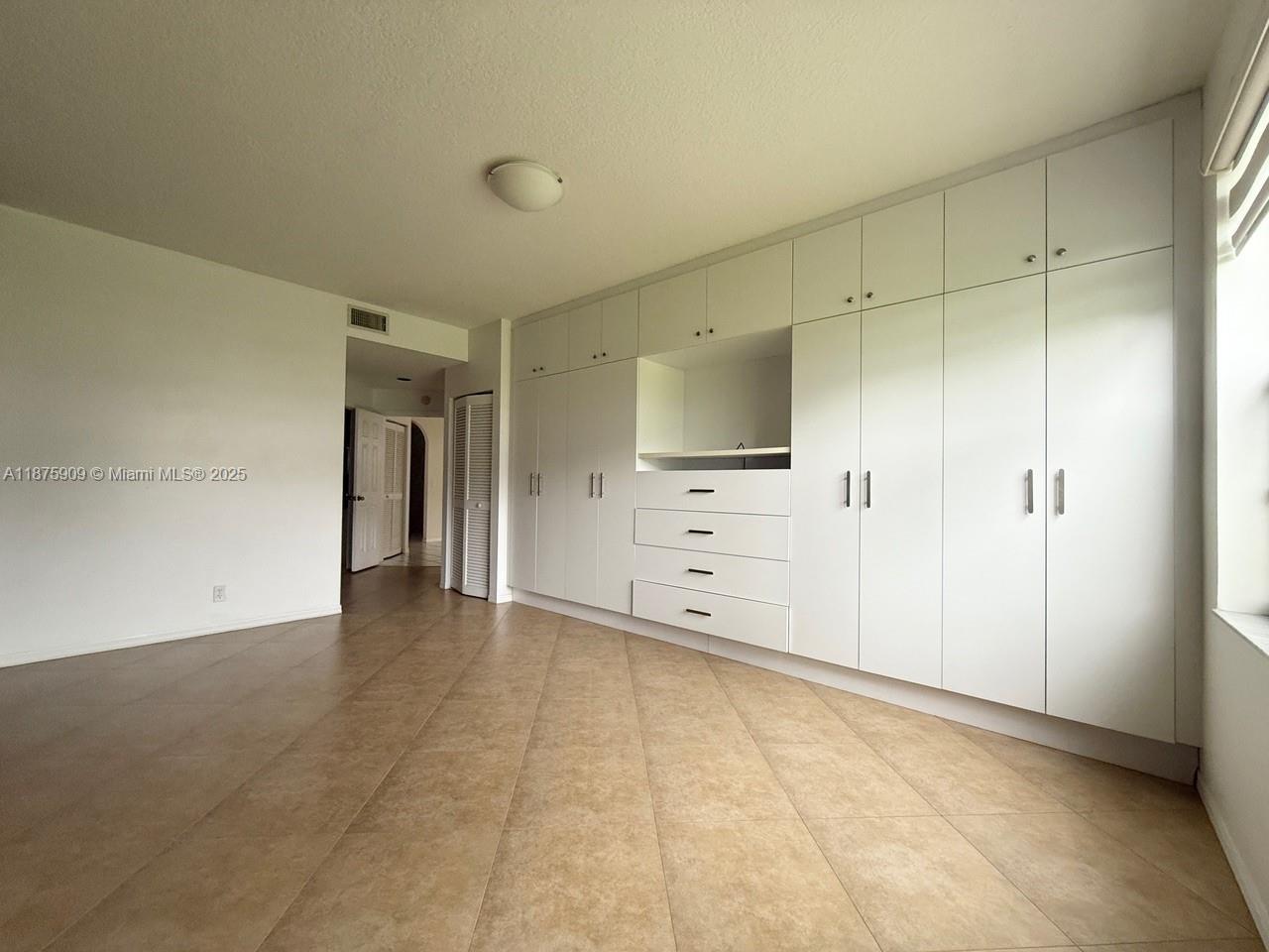 8658 Vía Reale, Unit 3 Boca Raton, FL 33496 - Photo 12 of 39 a view of an empty room with cabinet and mirrors