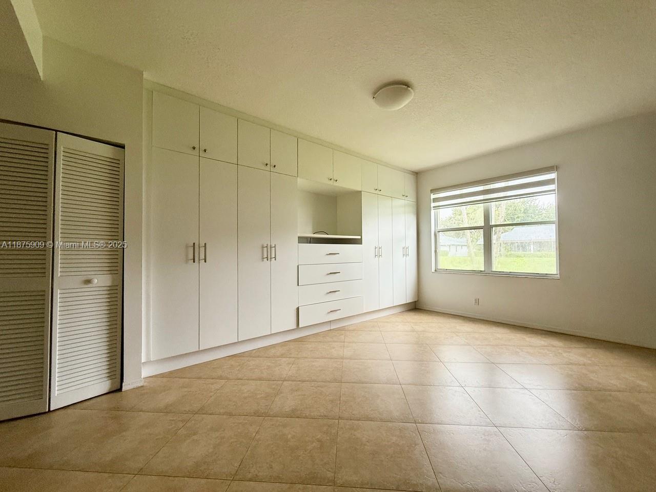 8658 Vía Reale, Unit 3 Boca Raton, FL 33496 - Photo 13 of 39 a view of an empty room with a fireplace and a window