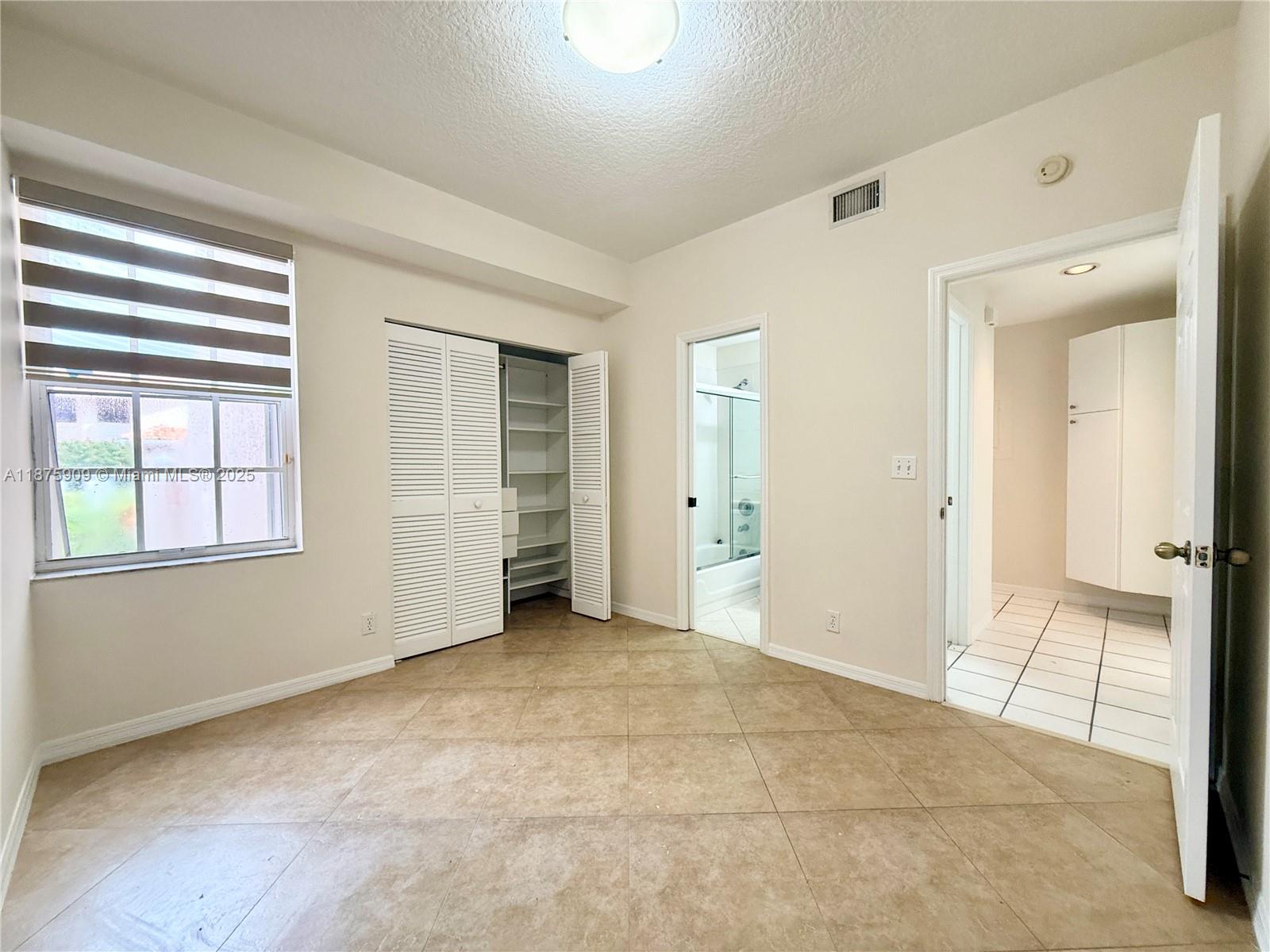 8658 Vía Reale, Unit 3 Boca Raton, FL 33496 - Photo 17 of 39 an empty room with windows and closet