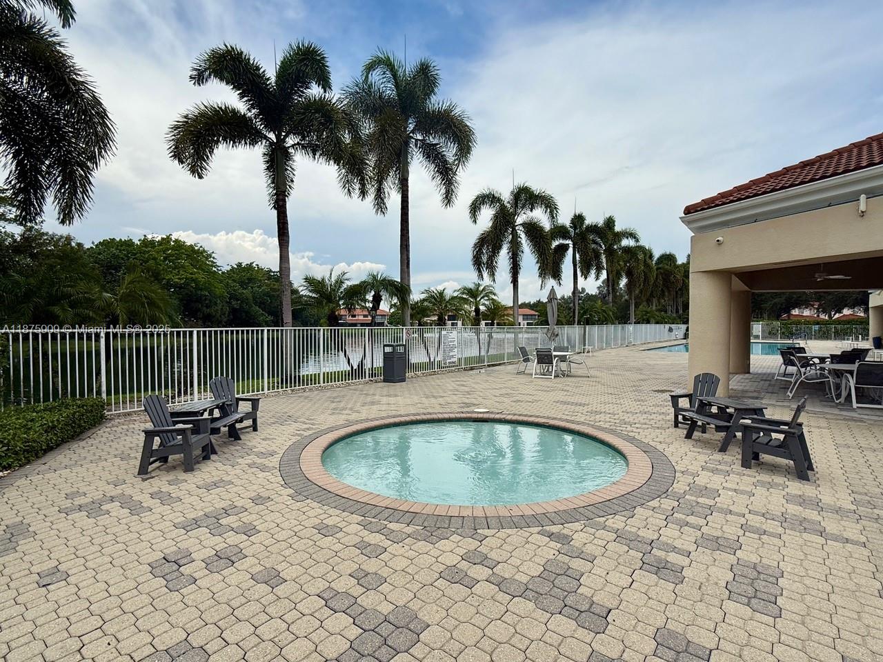 8658 Vía Reale, Unit 3 Boca Raton, FL 33496 - Photo 31 of 39 a view of a swimming pool with a table and chairs