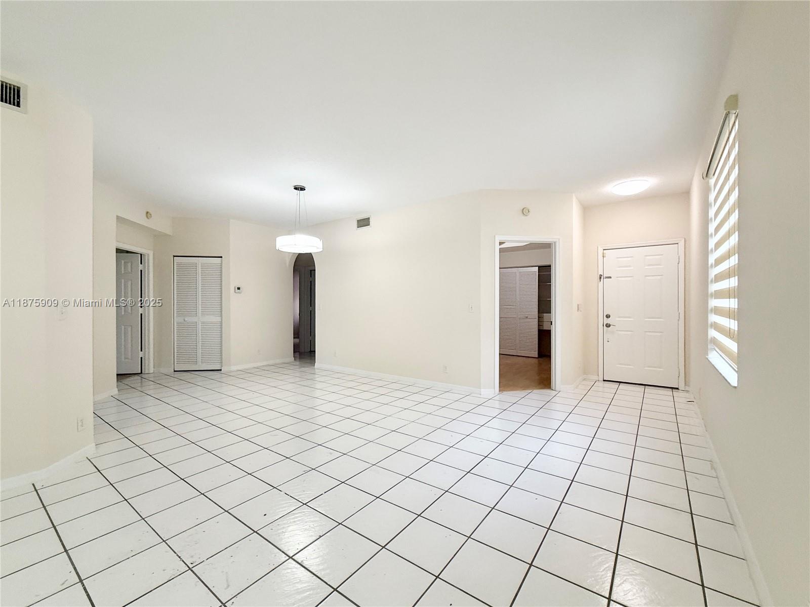 8658 Vía Reale, Unit 3 Boca Raton, FL 33496 - Photo 5 of 39 a view of a hallway with wooden floor and a refrigerator