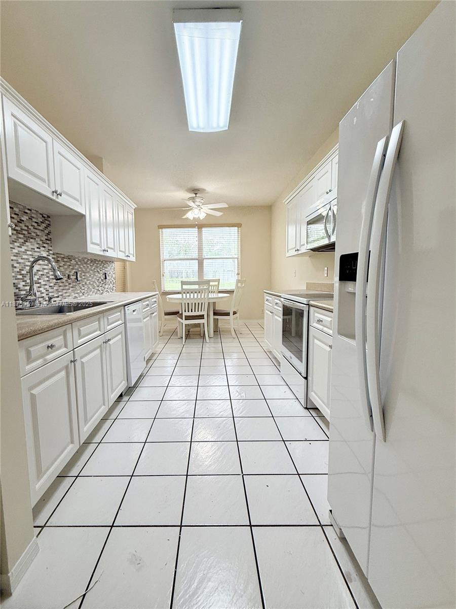 8658 Vía Reale, Unit 3 Boca Raton, FL 33496 - Photo 7 of 39 a kitchen with a sink a stove and refrigerator