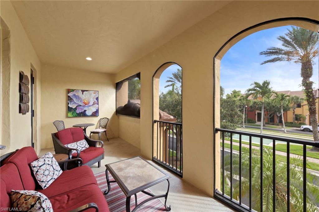 9076 Rialto Street, Unit 6204 Naples, FL 34113 - Photo 27 of 50 Screened lanai featuring arched openings, textured walls, recessed lighting, and a black metal railing. NEW NO-SEE-UM SCREEN (2025)