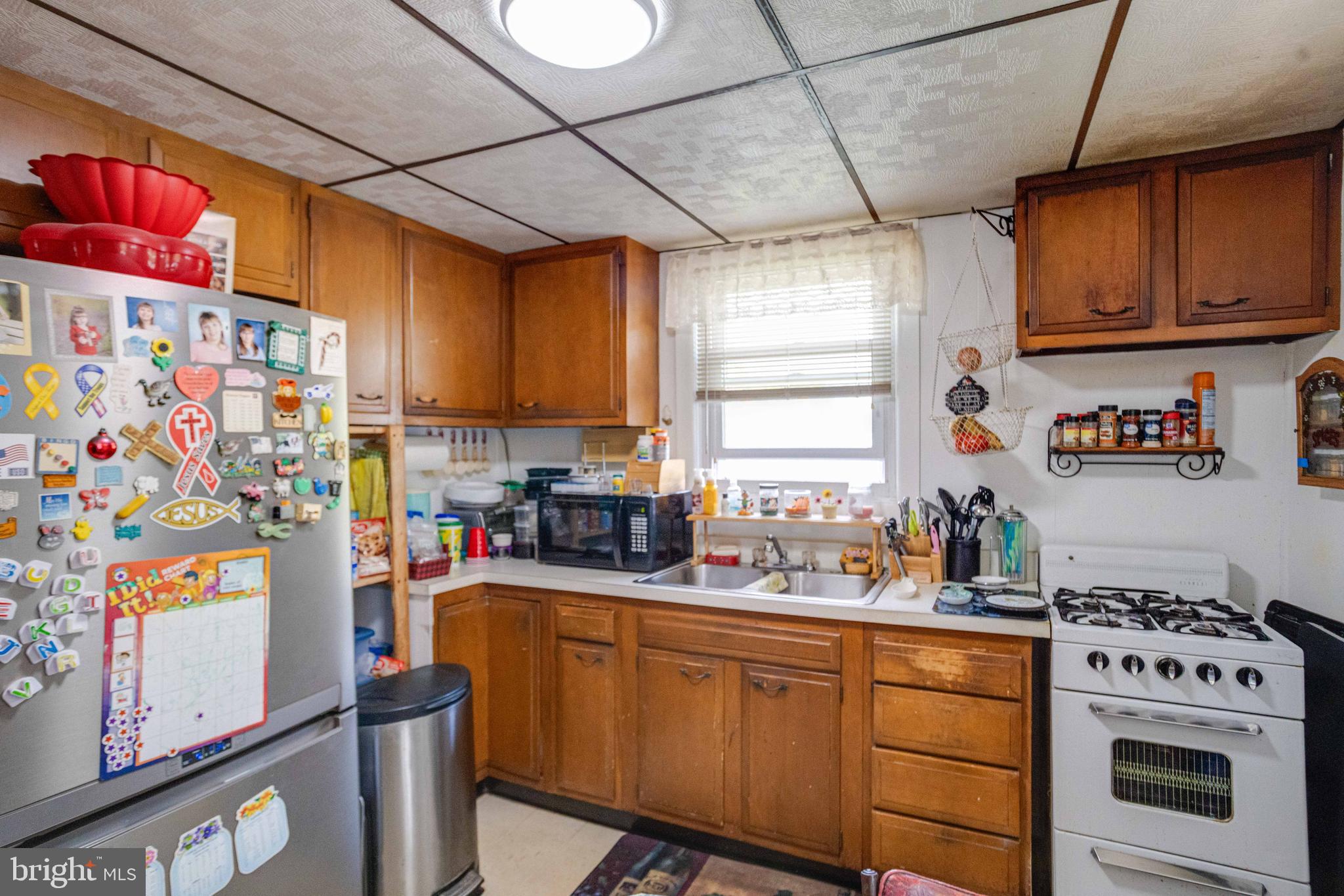 900 Renfrew Street Baltimore, MD 21221 - Photo 14 of 40 a kitchen with stainless steel appliances granite countertop a refrigerator and a stove top oven