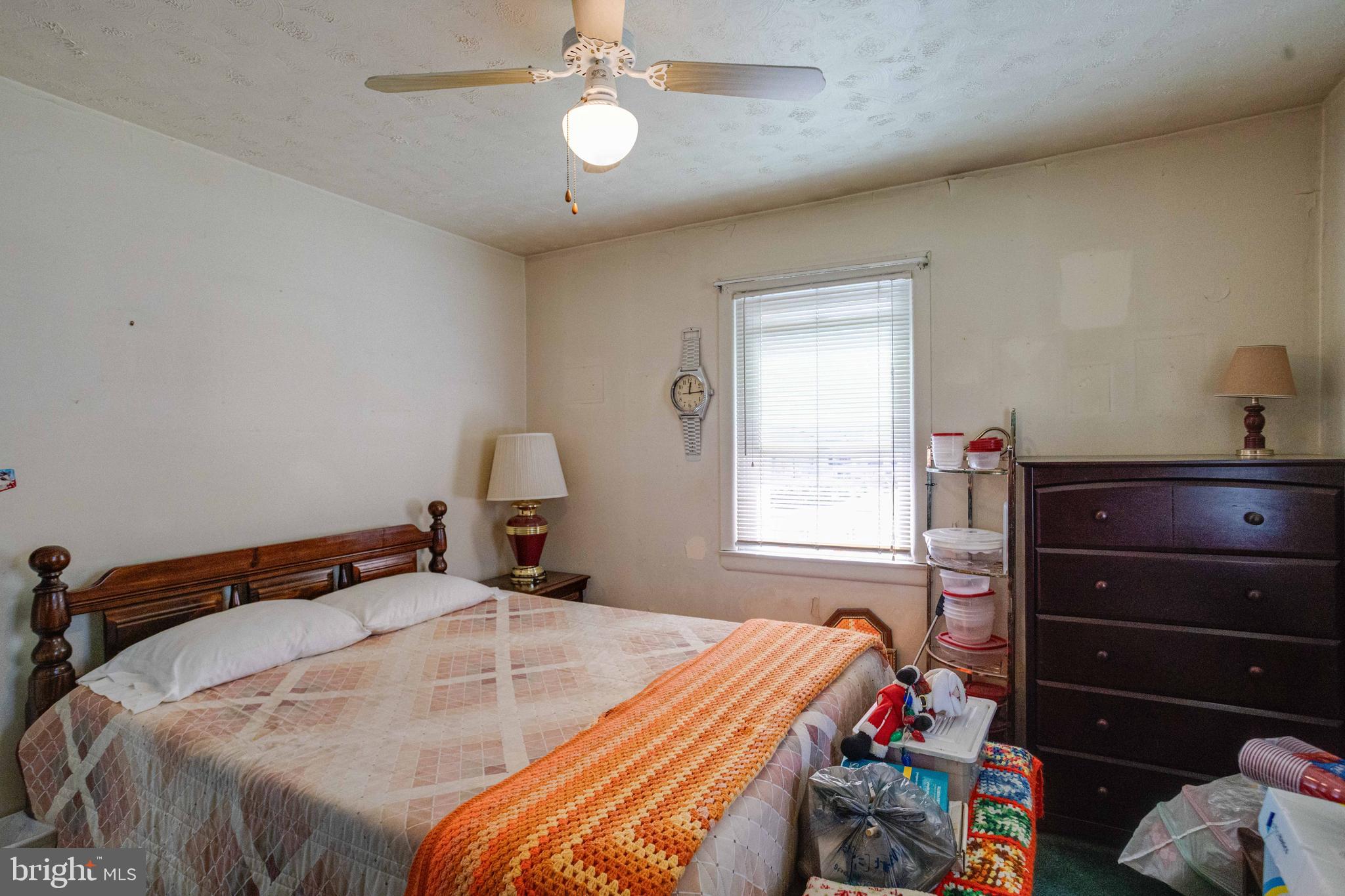 900 Renfrew Street Baltimore, MD 21221 - Photo 18 of 40 a bed sitting in a bedroom next to a window and a lamp