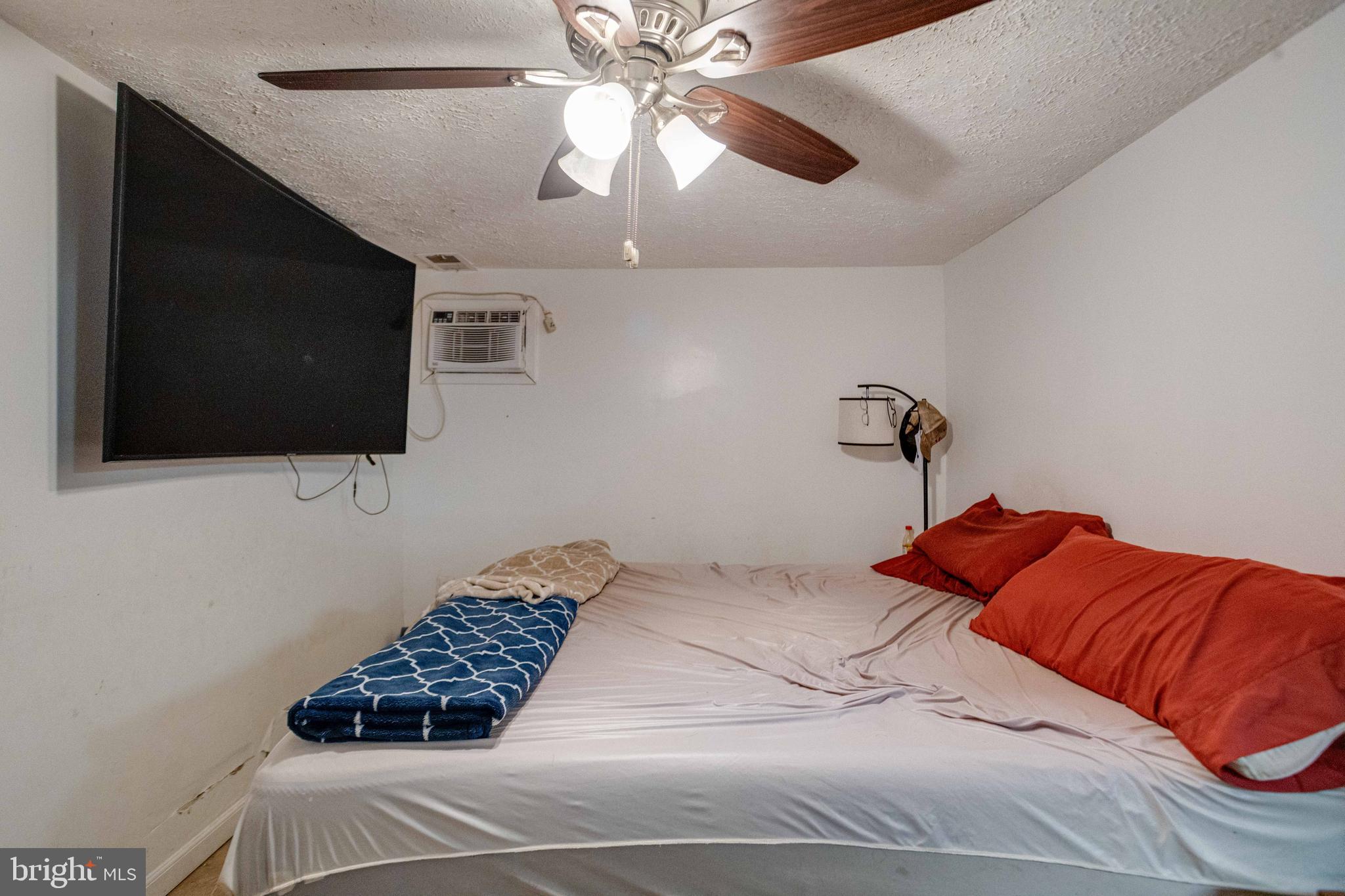 900 Renfrew Street Baltimore, MD 21221 - Photo 31 of 40 a bedroom with a bed and a flat screen tv