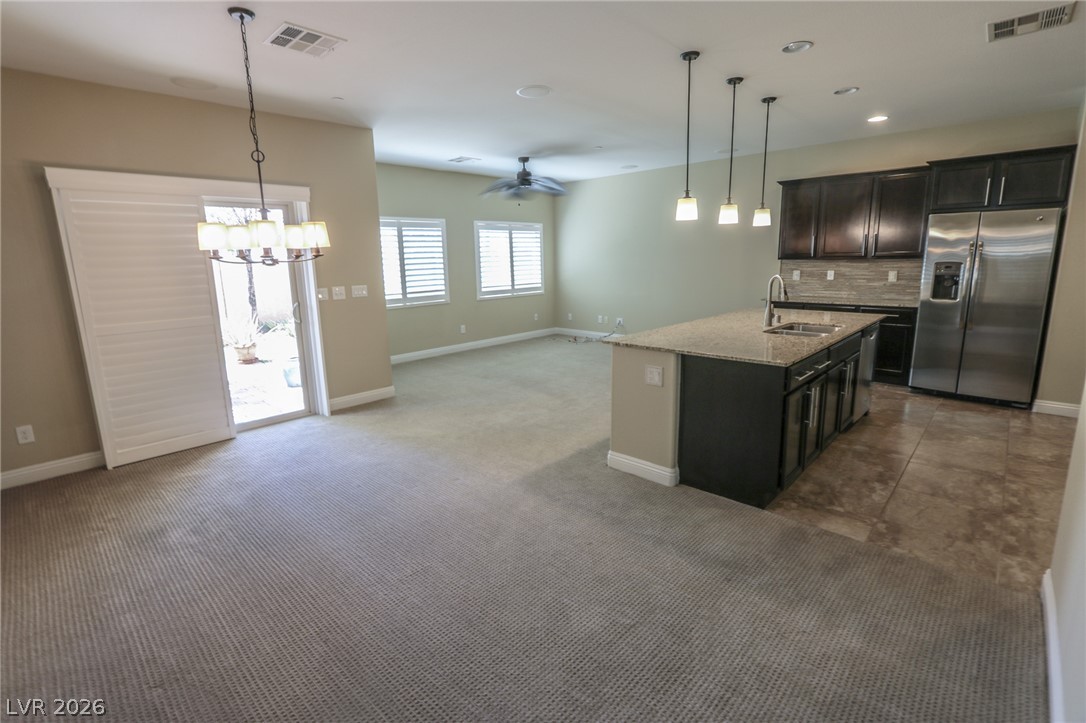 1509 Destiny Ridge Court Henderson, NV 89074 - Photo 29 of 29 An open floor plan connects the carpeted living areas to a tiled modern kitchen.