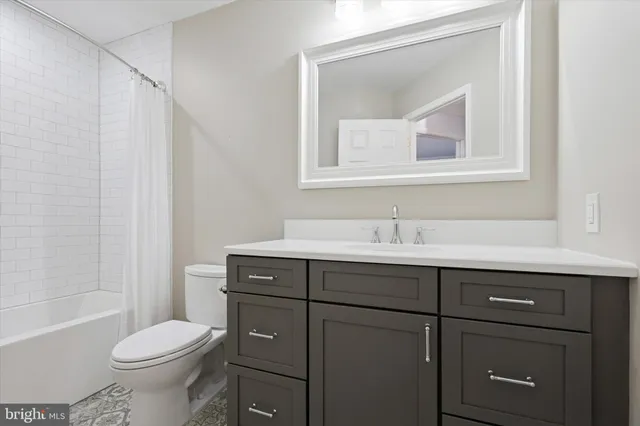 a bathroom with a sink toilet vanity and tub