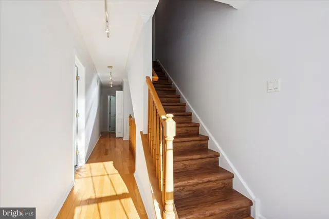 a view of staircase with wooden floor and white walls