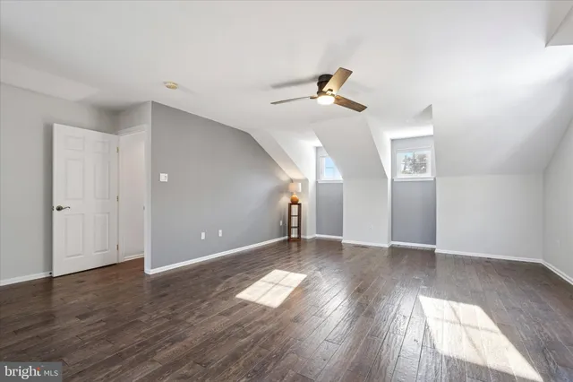 a view of empty room with wooden floor and ceiling fan