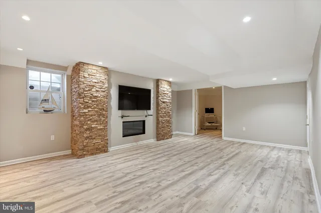 a view of an empty room with a fireplace and a window