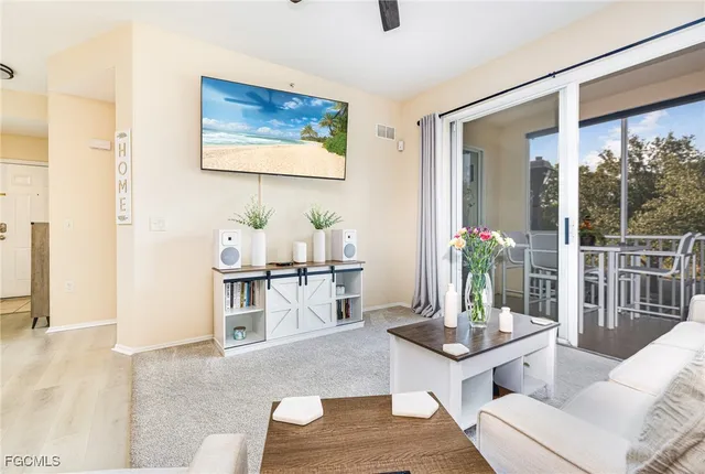 a living room with furniture potted plant and kitchen view
