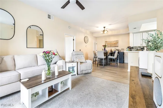 a living room with furniture kitchen view and a window