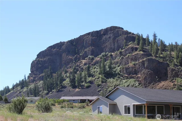 a front view of house with a mountain in the background