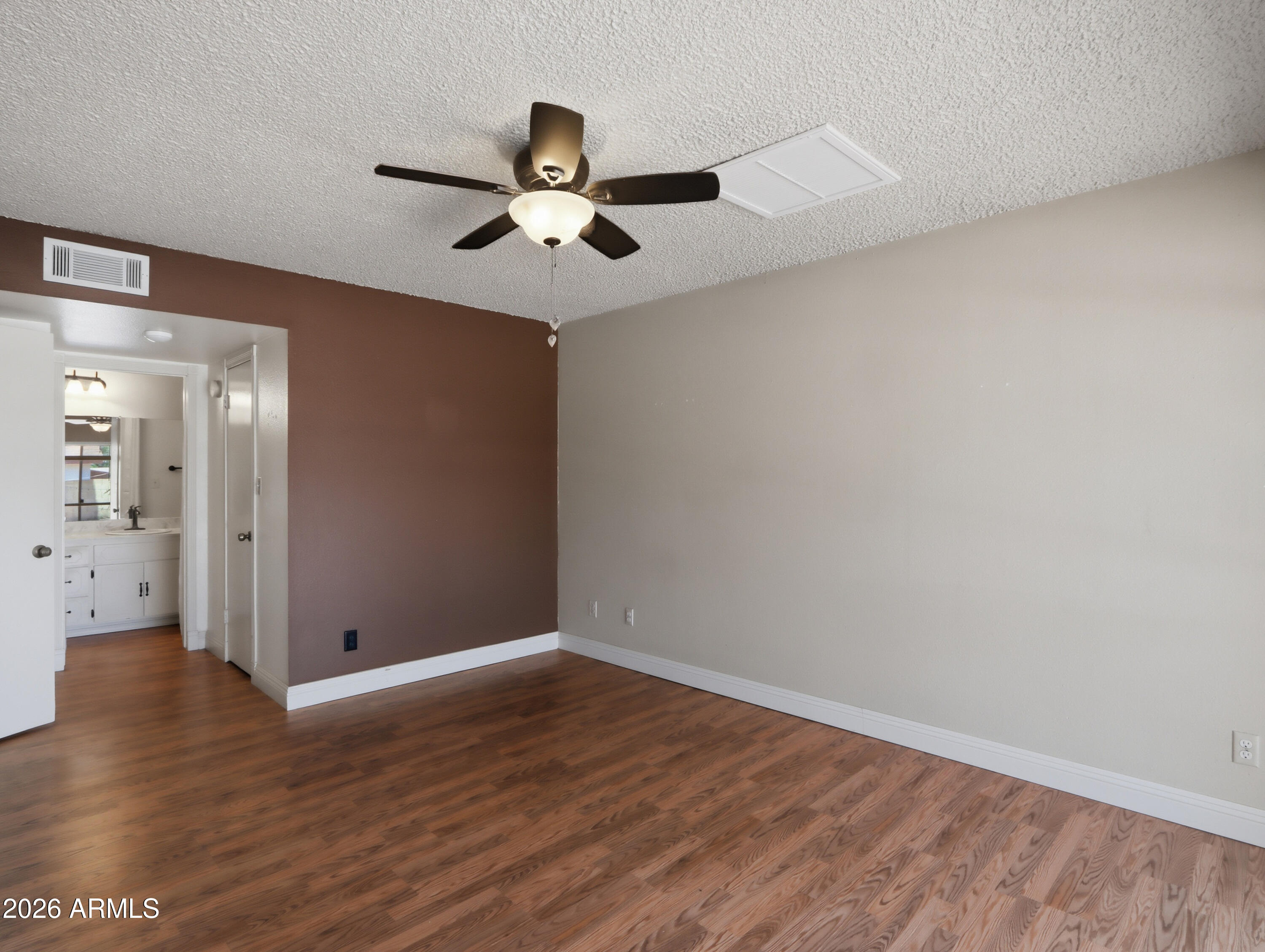 450 Cascada Road Litchfield Park, AZ 85340 - Photo 17 of 40 a view of an empty room with wooden floor