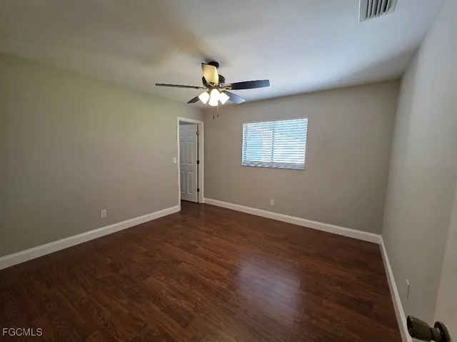 a view of wooden floor and a chandelier fan in a room