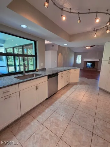 a large white kitchen with a large window and counter space