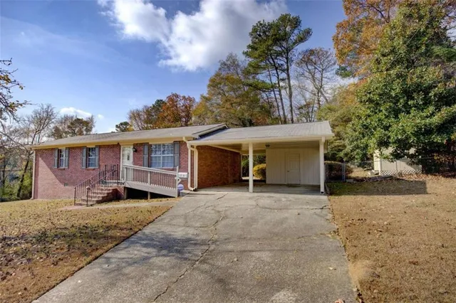 a view of a house with a yard and large tree