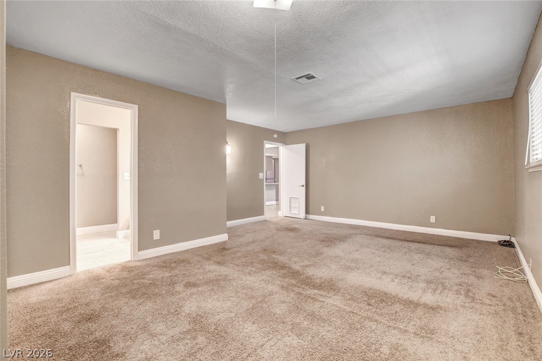 4367 South Mojave Road Las Vegas, NV 89121 - Photo 28 of 53 A spacious room offers comfortable carpeted flooring and ready access to additional areas through open doorways.