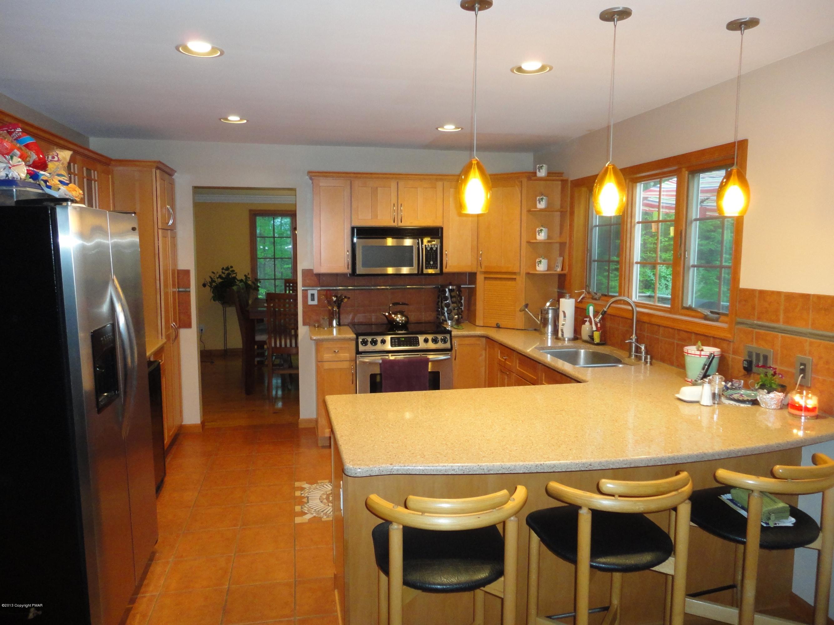 391 Turkey Ridge Road Mount Bethel, PA 18343 - Photo 4 of 19 a kitchen with a table chairs refrigerator and microwave