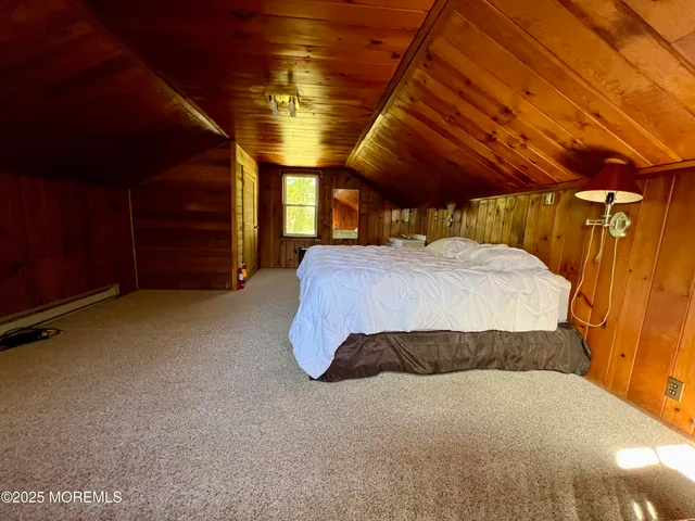 a bed sitting in a spacious bedroom next to a window
