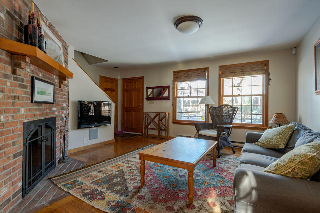 95 Cannon Hill Road Wellfleet, MA 02667 - Photo 3 of 36 a living room with furniture a fireplace a flat screen tv and windows