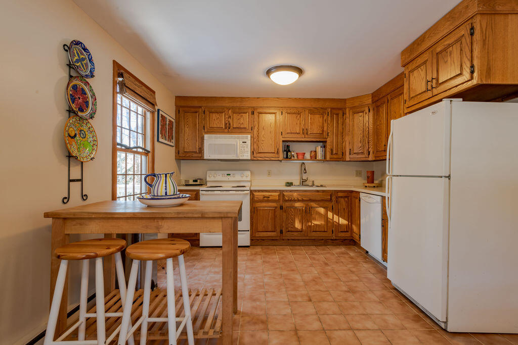 95 Cannon Hill Road Wellfleet, MA 02667 - Photo 7 of 36 a kitchen with kitchen island granite countertop a stove a sink and a refrigerator